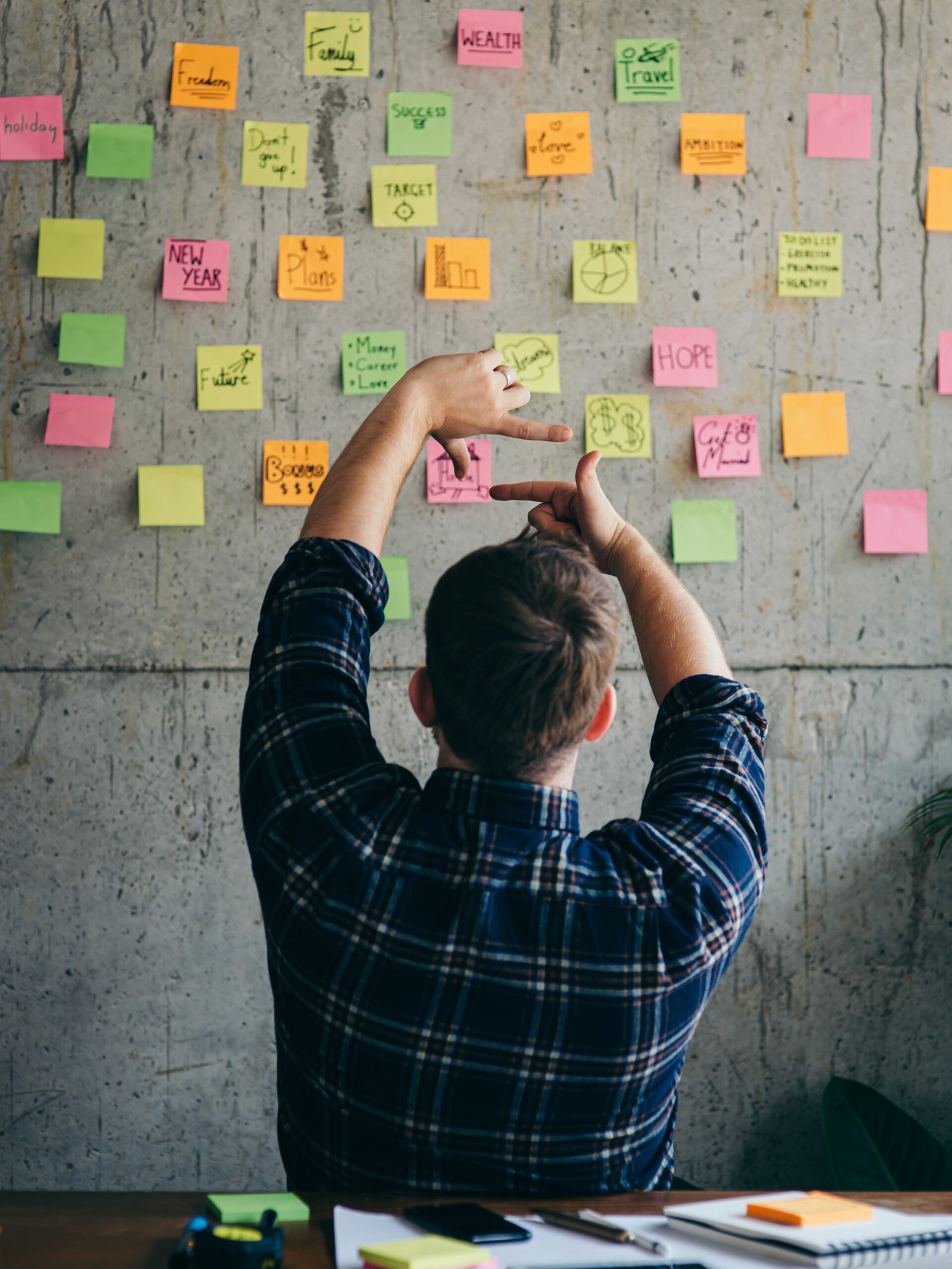 Back of entrepreneur sitting in office and look at colorful sticky notes