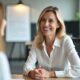 Happy blonde hr manager smiles at job applicant during interview at workplace. Executive women discuss project in corporate office recruiting employee or business consultation.